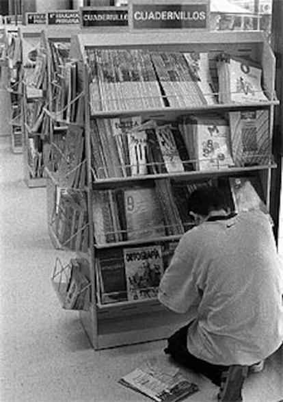 Un padre busca entre los libros de texto de una librería.