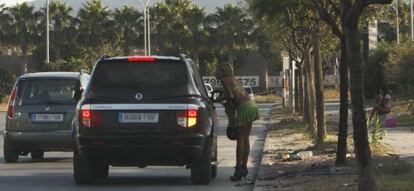 Una prostituta habla con un supuesto cliente en un polígono de Málaga.
