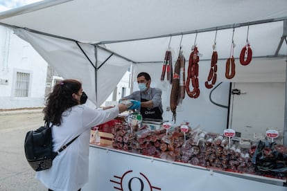 Quique Piris, de 38 años, despacha en su puesto de embutidos en el mercadillo de Cedillo.