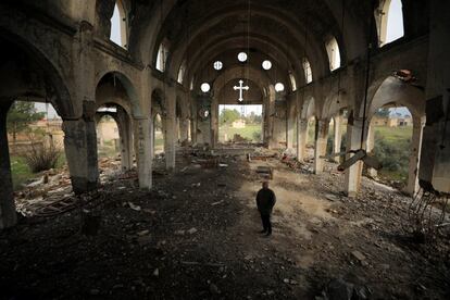 Sargon Slio, un agricultor sirio de 51 años, camina bajo las ruinas de una iglesia en el pueblo de Tel Nasri. 