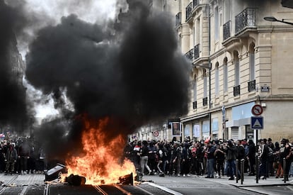 Los manifestantes queman contenedores en Burdeos durante las protestas contra la reforma de Macron, este jueves.