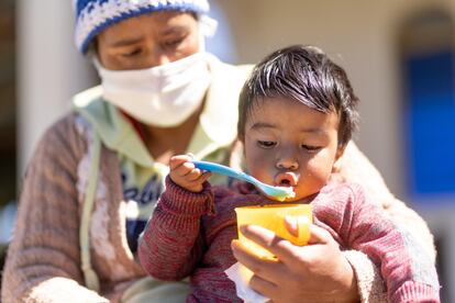 Erick Samuel, de 18 meses, come albaricoques, en Guatemala.