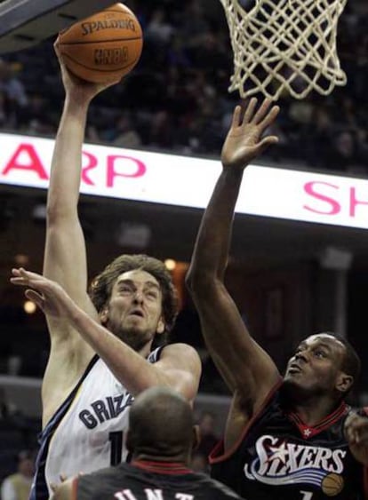 El ala pívot español de los Grizzlies de Memphis Pau Gasol lanza a canasta ante la defensa del pívot haitiano Samuel Dalembert  y Steven Hunter.