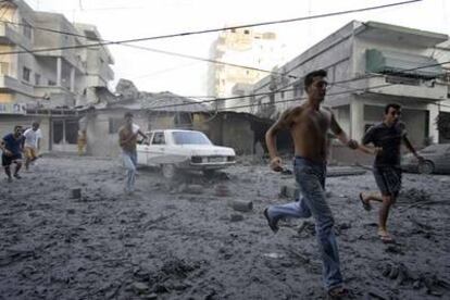 Varios libaneses se apresuran a ayudar a los supervivientes de un bombardeo israelí, que destruyó dos edificios ayer en el centro de la ciudad de Tiro.
