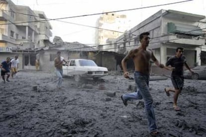 Varios libaneses se apresuran a ayudar a los supervivientes de un bombardeo israelí, que destruyó dos edificios ayer en el centro de la ciudad de Tiro.