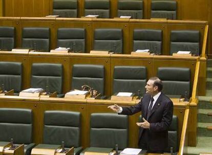 El lehendakari Ibarretxe interviene desde su escaño en medio de los asientos vacíos del Parlamento de Vitoria.
