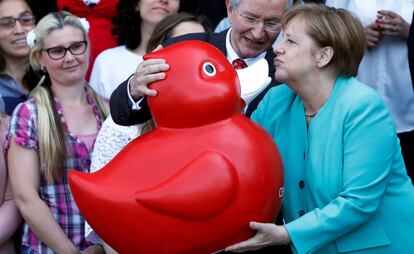 La canciller alemana, Angela Merkel, recibe un pato de juguete de Arndt Rolfs, CEO de Centogene AG, durante su visita a la empresa de biotecnología, en Rostock (Alemania).