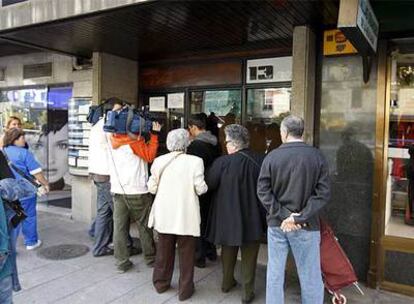 Vecinos, cámaras y curiosos, en la puerta de la calle Reina Victoria número 13 de Madrid en el que vivía la mujer apuñalada.