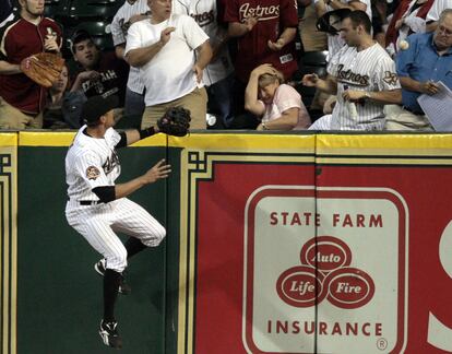 El jugador de los Houston Astros, Hunter Pence, salta para intentar hacerse con una bola golpeada por el bateador Mark DeRosa, de los San Francisco Giants, mientras una señora se lleva la mano a la cabeza tras recibir el impacto.