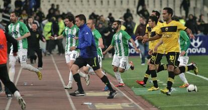 El árbitro y jugadores del Panthratikos y el AEK corren a refugiarse en el vestuario