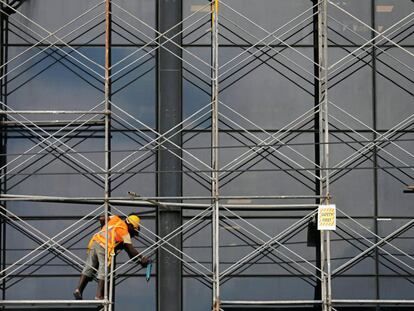 Un hombre inspecciona las ventanas de vidrio después de las reparaciones de un edificio en Colombo, Sri Lanka.