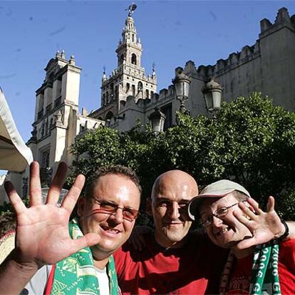 Tres aficionados del Liverpool, ayer, en las inmediaciones de la catedral de Sevilla.