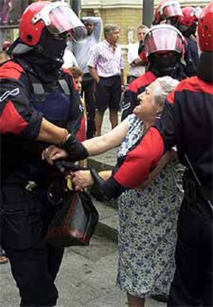 Varios <I>ertzainas</I> forcejean con una mujer en Bilbao.