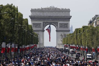 Aficionados esperan la llegada del equipo nacional francés en la avenida Champs-Elysees, cerca del Arco del Triunfo, en París.