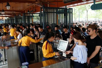Centenares de personas esperan su turno para poder acceder al parque Disney de Shanghái.
