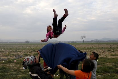 Un grupo de niños se mantea en un campamento improvisado para los migrantes y refugiados en la frontera entre Grecia y Macedonia, cerca de la localidad de Idomeni (Grecia).