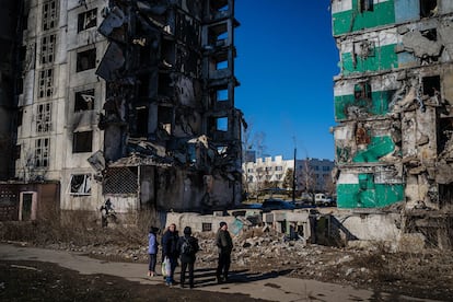 Ciudadanos ucranianos, ante un edificio destrozado en un ataque ruso en Borodyanka, el 23 de febrero de 2023. (DILKOFF / AFP)