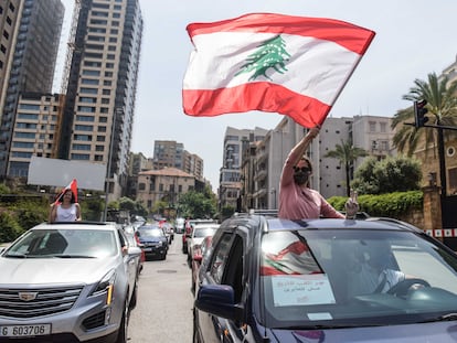 Una manifestante ondea la bandera libanesa durante un convoy de protesta durante la sesión parlamentaria este martes en Beirut