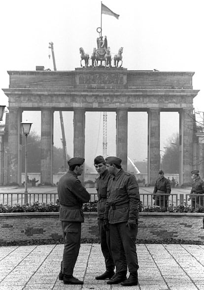 Un grupo de 'volgos' conversa frente a la Puerta de Brandemburgo. Tras la construcción del Muro en 1961 fueron en parte los responsables de evitar cualquier fuga. Tenía orden de disparar contra cualquiera que intentar cruzar al otro lado. Temidos por la población, su autoridad se desmoronó en apenas unas horas.