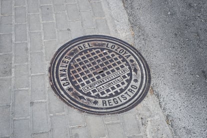 
Una alcantarilla con la inscripción "Canales del Lozoya" en una calle de la colonia.