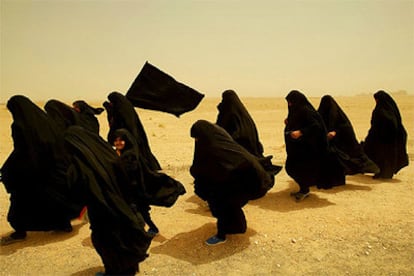 Un grupo de mujeres chiíes se dirige a la ciudad santa de Kerbala, a través de una tormenta de arena, en abril de 2003.