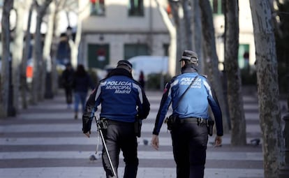 Dos policías Municipales patrullando por un bulevar de Puente de Vallecas, Madrid. 