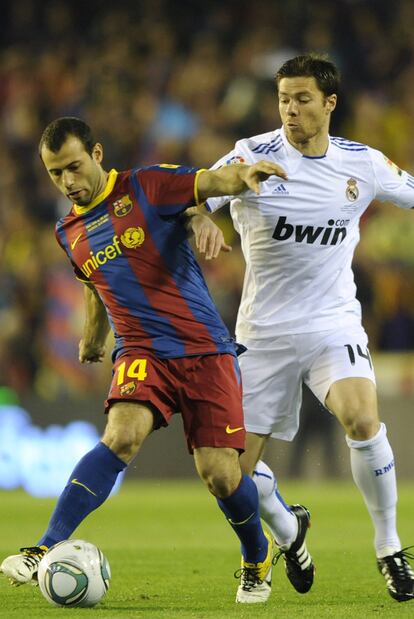 Mascherano y Xabi Alonso pugnan por hacerse con el balón.