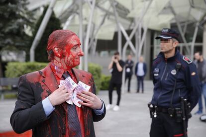 Una persona tras rociarse con pintura roja en protesta por la Junta de Accionistas de BBVA, en la que la entidad pide autorización para elevar el salario fijo de sus tres consejeros ejecutivos.