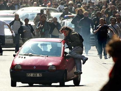 Un estudiante intenta detener un coche después de que su conductor atropellara a un grupo de manifestantes.