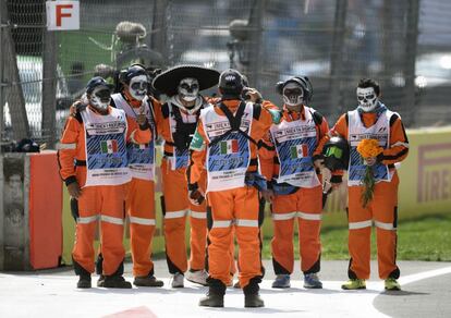 Un grupo de comisarios del Gran Premio participa en una ofrenda en el circuito de la capital mexicana. 