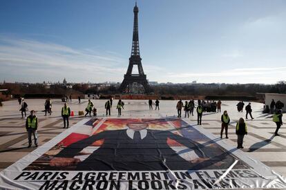 Activistas junto a un cartel del presidente francés Emmanuel Macron que reza “Macron mira hacia otro lado mientras el Acuerdo de París está en llamas”, el jueves pasado en la plaza del Trocadero, frente a la Torre Eiffel.