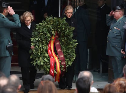 Cristina Cifuentes, y la alcaldesa de Madrid, Manuela Carmena, colocan una corona de laurel en la fachada de la Real Casa de Correos de la Puerta del Sol ante la placa que recuerda a las 193 personas que murieron hace 14 años en los atentados del 11 de marzo de 2004.