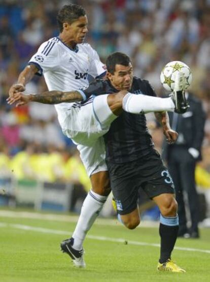 Varane trata de despejar en balón ante Tévez