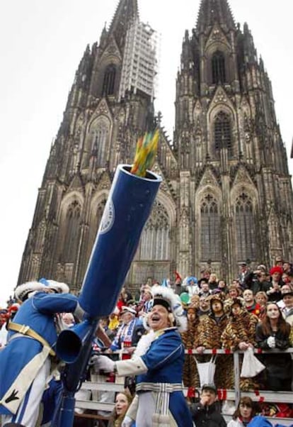 Los participantes del desfile que recorre Colonia el lunes de carnaval disparan dulces para el público frente a la catedral.