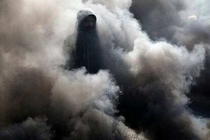 Un manifestante, entre el humo de los neumáticos en llamas, durante las continuas protestas antigubernamentales en Kerbala (Irak).