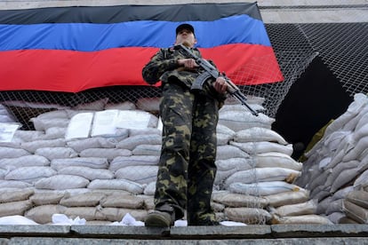 Um homem armado com vestimenta militar monta guarda diante de um edifício da administração regional tomado pelos separatistas pró-russos em Slavansk, ao leste da Ucrânia.