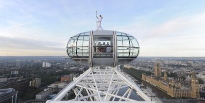 La esquiadora Amelie Hempleman-Adams sostiene la antorcha olímpica sobre una cabina del London Eye