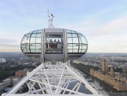 La esquiadora Amelie Hempleman-Adams sostiene la antorcha olímpica sobre una cabina del London Eye