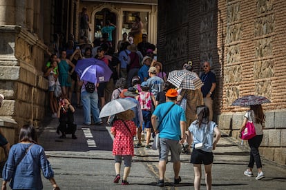 Turistas se protegen del sol mientras pasean por Toledo, que se encuentra en aviso naranja por ola de calor, este jueves.
