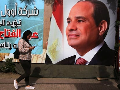 Una mujer pasa ante un cartel electoral de Abdelfatá al Sisi en El Cairo.