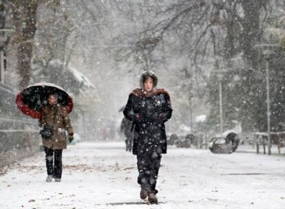 Una mujer cruza el parque de la Florida de Vitoria durante la nevada caída esta mañana.