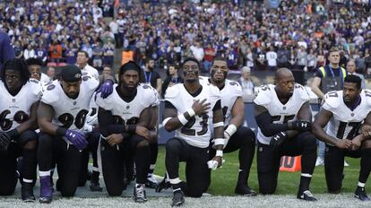 Jogadores dos Ravens se ajoelham durante a execução do hino neste domingo.