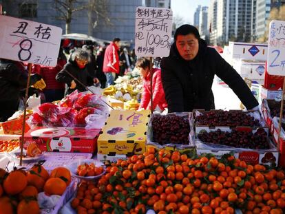 Un vendedo de fruta espera en un mercado local de Pek&iacute;n (China