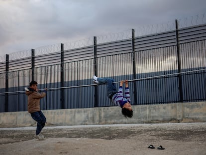 Dos niños palestinos desplazados debido a los ataques israelíes juegan cerca de la valla fronteriza con Egipto, este martes en Rafah (Franja de Gaza).