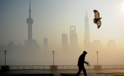 Un hombre con una cometa entre la contaminación de Shanghái.
