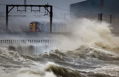 Un tren pasa a lo largo de la costa en Saltcoats en Escocia. Las fuertes lluvias traerán más inundaciones en muchas partes del país.