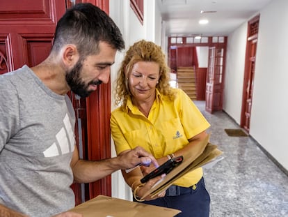 Ángeles Nava, cartera, reparte la documentación de voto por correo en el barrio de Lavapiés de Madrid.