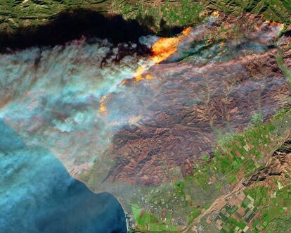 El incendio Thomas, en el condado de Ventura, al norte de Los Ángeles, visto desde el espacio el pasado martes 5 de diciembre. Desde entonces, el incendio ha crecido por la montaña que se ve al sur de las llamas hacia Santa Paula (las casas a la derecha de la foto) y Ventura (en el puerto). El domingo había quemado ya 93.000 hectáreas, más que la superficie de la ciudad de Berlín. El invierno pasado fue uno de los más lluviosos de la historia en un territorio poco acostumbrado, y eso ha llenado las zonas rurales de California de combustible para los incendios.