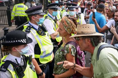 Dos manifestantes se enfrentan a la policía durante una protesta antivacunas celebrada en los alrededores del Parlamento británico, en Londres, Reino Unido.