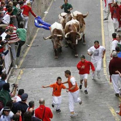 Luis Miguel Gómez corre delante de los mansos junto a su hijo y otro menor (a su espalda).